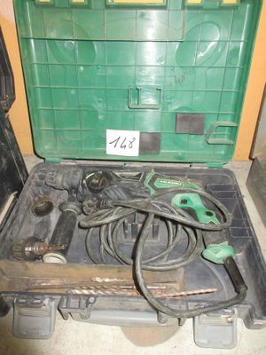 une boîte à outils verte posée par terre, contenant des outils