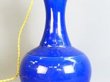 a blue vase with a gold handle on a table