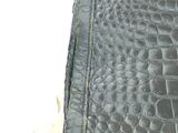 a close up of a black leather purse on a white surface