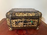 une boîte noire et dorée posée sur une table en bois