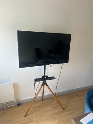 un téléviseur à écran plat posé sur un trépied dans un salon
