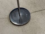 a metal pole that is on the ground next to a parking meter