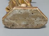 a statue of a woman holding a gold purse