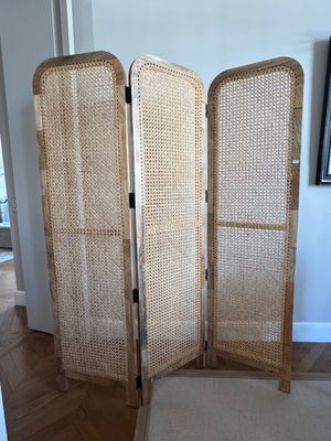 un paravent en osier avec un banc devant
