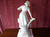 a statue of a woman holding a bird on a table