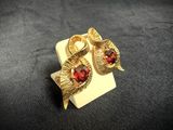 a close up of a pair of earrings with red stones