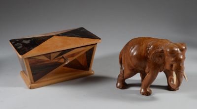 un petit éléphant en bois à côté d'une petite boîte en bois