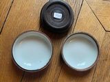 two cups of milk sitting on the floor next to each other
