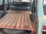 an old blue truck with a wooden bed in the back of it