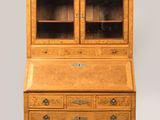 un bureau ancien en chêne avec des portes vitrées et des tiroirs