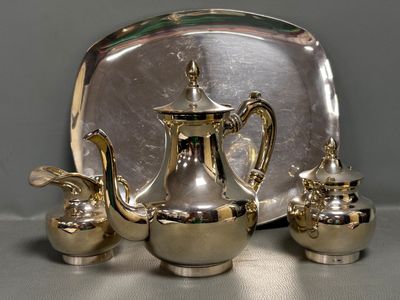 un plateau en argent sur lequel sont posés une théière en argent et deux tasses en argent