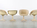 three beige chairs sitting next to each other on top of a cement floor