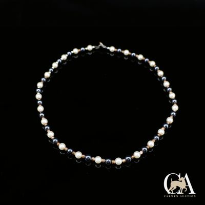 un gros plan d'un collier de perles sur fond noir