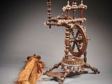 un rouet et un morceau de bois posés sur une table