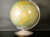 un petit globe posé sur un socle, sur une table