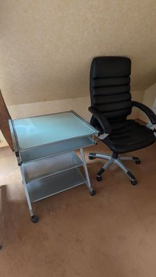 un bureau avec une chaise et une table à plateau en verre