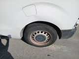 a white van with a flat tire parked in a parking lot