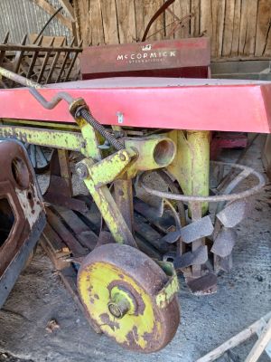 un vieux tracteur équipé d'une charrue, dans une grange