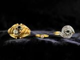 two gold and silver rings with diamonds on a black background
