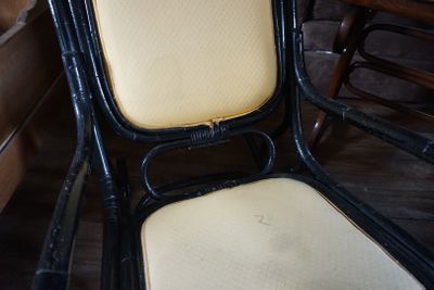 une chaise noire avec une assise jaune et un coussin blanc