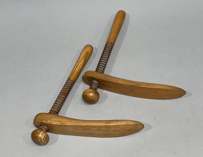 deux battes de baseball en bois et une balle posées sur une table
