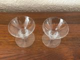 two empty wine glasses sitting on top of a wooden table