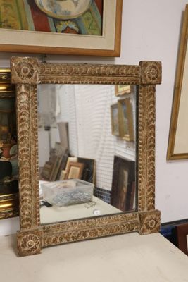 a mirror sitting on top of a table next to a painting