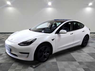 La Tesla Model 3 blanche est garée sur un sol à damier