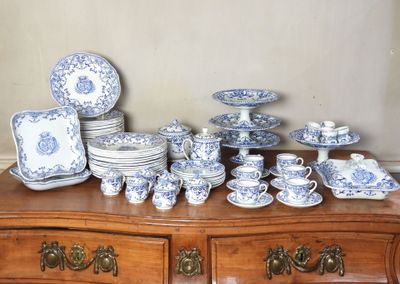 une commode sur laquelle sont disposées de nombreuses pièces de vaisselle bleue et blanche