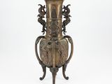 a bronze vase on a stand on a white background