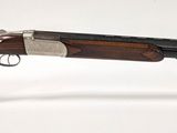 un fusil posé sur un socle en acrylique transparent, sur une surface blanche