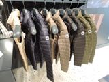 many jackets hanging on a rack in a store