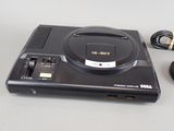 a video game system sitting on a table next to a charger