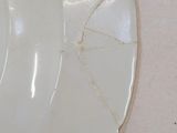 a white plate with a crack in it on a table