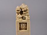 two carved ivory figurines of two lions on a pedestal