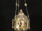 an ornate brass hanging lamp with a bird on it