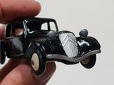 someone is holding a toy car in their hand on a white surface