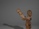 une image représentant une sculpture en bois d'une femme tenant une balle