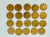 a close up of a bunch of gold coins on a white surface