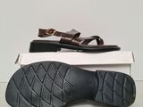 a pair of brown sandals sitting on top of a white box
