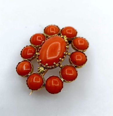 une image représentant une broche orange posée sur une surface blanche