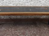 une petite table avec un plateau en verre, posée sur un sol recouvert de moquette