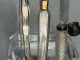 deux bouteilles en verre et un vase en argent posés sur une table