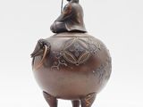 a statue of a woman sitting on top of a pot