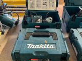 Trois outils Makita sont posés sur une table dans un atelier