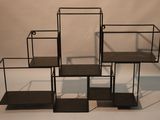 three black metal shelves are stacked on top of each other