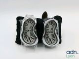 une paire de montres-bracelets argentées et noires, ornées de chiffres romains