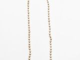collier de perles sur fond blanc, avec un fermoir doré