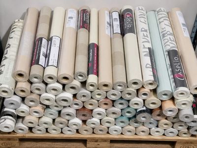 de nombreux rouleaux de tissu posés sur une palette en bois