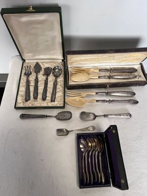 une boîte à couverts posée sur une table, contenant un couteau, une fourchette et des cuillères